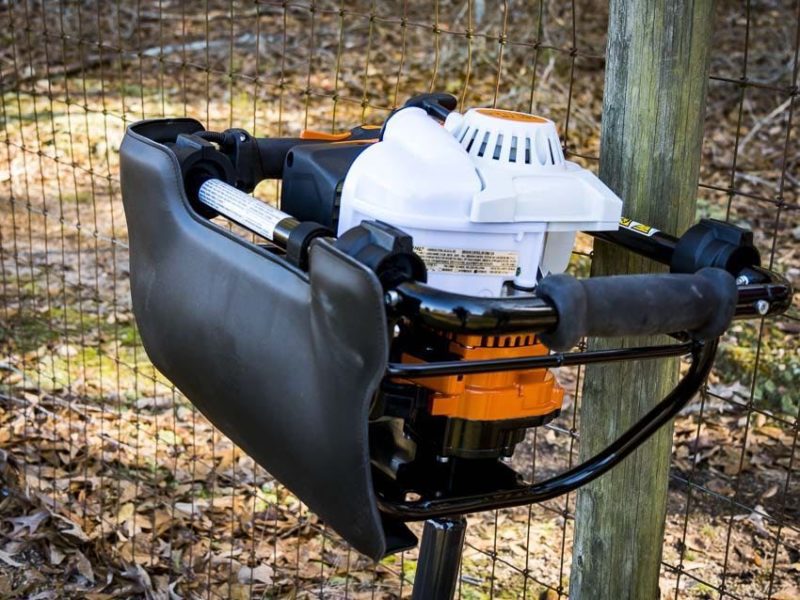 auger leaning against fence